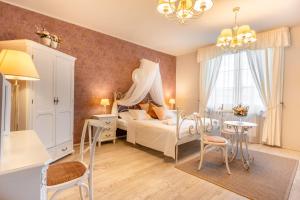 1 dormitorio con 1 cama, mesa y sillas en Hotel Plumlov, en Mostkovice
