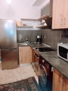 una cucina con frigorifero in acciaio inox e lavastoviglie di 4U SuperCentral,seaside,cosy family apartment a Salonicco