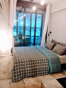 a bedroom with a bed with a checkered blanket at 4U SuperCentral,seaside,cosy family apartment in Thessaloniki