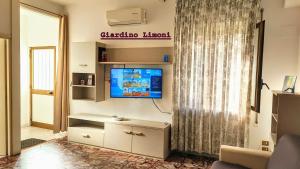 een woonkamer met een tv en een gordijn bij Il Giardino Dei Limoni in Gaeta