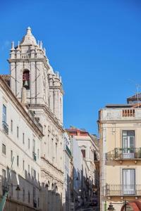 a tall building with a clock tower on a street at Inglesinhos Convento 3 - Bright Apartment in Lisbon
