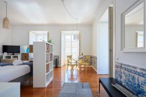 a bedroom with a bed and a living room at Inglesinhos Convento 3 - Bright Apartment in Lisbon