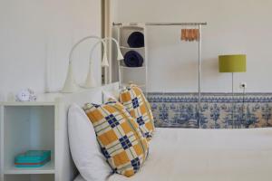 a living room with a couch and a lamp at Inglesinhos Convento 3 - Bright Apartment in Lisbon