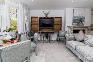 a living room with a couch and a piano at Glamorous 2-bedroom, Central location, Scenic Views - Central Park Suite in Parkstone