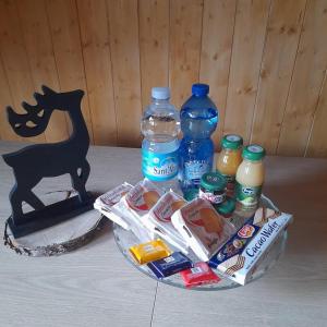 uma mesa coberta com garrafas de água e alimentos em Mansarda delle Dolomiti nuovissimo appartamento em Madonna di Campiglio