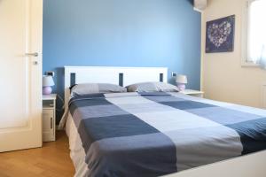 a blue and white bed in a bedroom with two lamps at Casa Monia By Case al Lago in Lonato