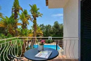 uma varanda com uma mesa com um livro em Villa 3 quartos piscina a 3km Vilamoura em Boliqueime