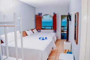 a bedroom with two beds and a view of the ocean at Pousada Estrela da Luz Beach in Ceará-Mirim
