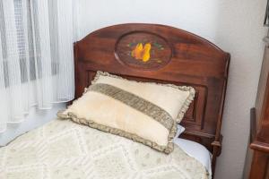 a bed with a wooden head board with a pillow at Etno selo Stanišići Hotel Pirg in Dvorovi