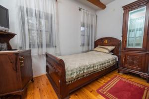 a bedroom with a bed and a dresser and a television at Etno selo Stanišići Hotel Pirg in Dvorovi