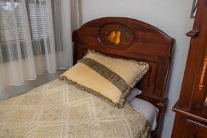 a bed with a wooden head board with a pillow at Etno selo Stanišići Hotel Pirg in Dvorovi