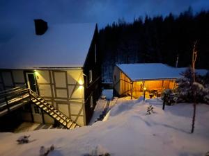 Una casa en la nieve por la noche en Haus am Bach en Neuwerk