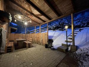 Zimmer mit einer schneebedeckten Wand mit einem Tisch und einer Treppe in der Unterkunft Haus am Bach in Neuwerk