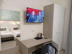 une chambre d'hôtel avec une télévision murale dans l'établissement La Dea Rooms, à Ferrare