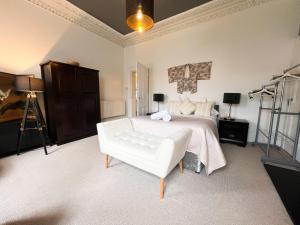 1 dormitorio con 1 cama blanca y 1 silla blanca en Garnethill Charm 3 Bed Flat Central Glasgow en Glasgow