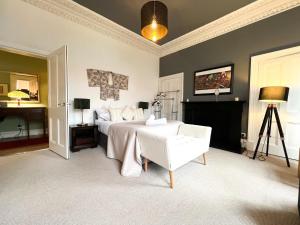 1 dormitorio con 1 cama, 1 silla y chimenea en Garnethill Charm 3 Bed Flat Central Glasgow en Glasgow