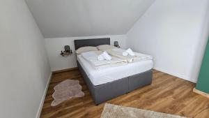 a bedroom with a bed with white sheets and towels at Christians Alpenparadies in Bad Mitterndorf