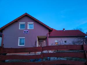 una casa con techo rojo y valla en Bella Vendégház en Székesfehérvár