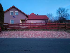 a house with a red fence and a brick driveway at Bella Vendégház in Székesfehérvár
