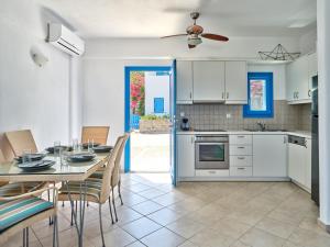 een keuken en eetkamer met een tafel en stoelen bij Paros Luxury Villa 2mins from the beach in Piso Livadi