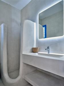 een badkamer met een wastafel en een spiegel bij Paros Luxury Villa 2mins from the beach in Piso Livadi