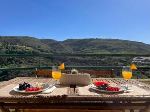 a table with plates of food and glasses of orange juice at Casa do Mar - Sea view - Wifi - Barbecue in Sesimbra