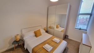 a bedroom with a bed with two towels on it at Southsea Escape Coastal Apartment, 2 double bedrooms in Portsmouth