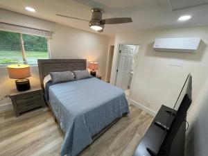 - une chambre avec un lit et une télévision à écran plat dans l'établissement Efficiency in a guest house close to Wellington, à Loxahatchee