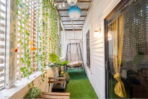 un pequeño balcón con plantas y un columpio en Charming Homey Midtown Oasis W/Tropical Patio en Atlanta