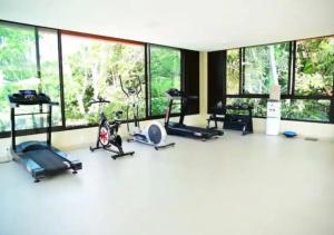 a gym with cardio equipment and large windows at Apartamento em Carneiros à beira- mar - Ao lado da igrejinha dos carneiros e do bora-bora in Tamandaré