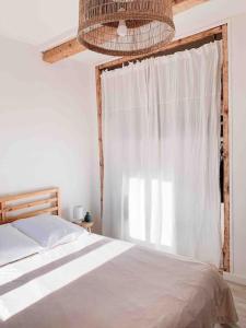 a bedroom with a white bed and a window at Écume: Duplex lumineux au cœur du village in Port-Vendres