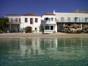 a white house on the beach next to the water at Fishermen Beach House in Dhiakofti