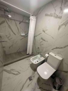 a bathroom with a white toilet and a sink at Elegante departamento a estrenar 2 Dormitorios in Villa Marini