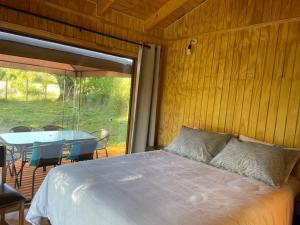 a bedroom with a bed and a table with chairs at Comodidad y hermosa Vista Volcán in Melipeuco