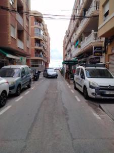una calle con coches estacionados al costado de la carretera en Casa sol y mar 2I, en Torrevieja