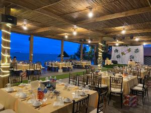 a banquet hall with tables and chairs and the ocean at Hòn Cau Resort & Restaurant in Tuy Phong