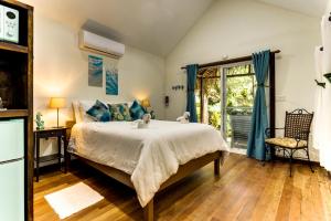 Un dormitorio con una cama grande y una ventana en Azure Del Mar en Maya Beach