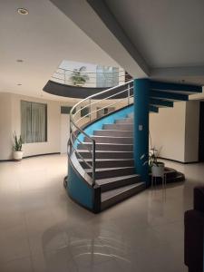 a spiral staircase in a building with a pool at Hospedaje La Lisera Suite in Tacna