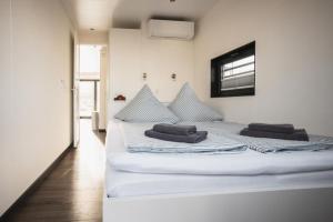 ein weißes Bett mit zwei Kissen auf einem Zimmer in der Unterkunft Hausboot Paradise - LP9 in Peenemünde