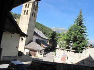a building with a tower with a tree in front of it at Maison de vacances 2 chambres, Wi-Fi, à Saint-Chaffrey - FR-1-762-15 in Saint-Chaffrey