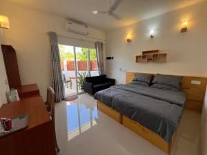 een slaapkamer met een bed en een woonkamer bij The Wave Dhigurah in Dhigurah