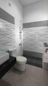 a bathroom with a toilet and a sink and a shower at Green House with Pool in Bonorejo