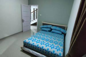 um quarto com uma cama com lençóis e almofadas azuis em Green House with Pool em Bonorejo