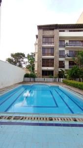 a large swimming pool in front of a building at Baraka Suites, Nyali Gulf Links Apartment by Gash Homestays C-1 in Mombasa