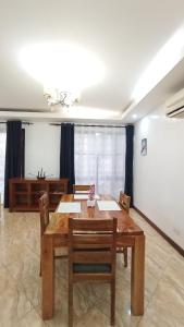 ein Esszimmer mit einem Holztisch und Stühlen in der Unterkunft Baraka Suites, Nyali Gulf Links Apartment by Gash Homestays C-1 in Mombasa