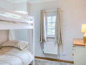 a bedroom with a bunk bed and a window at Mylo’s Cottage - Langrick, Lincolnshire in Boston