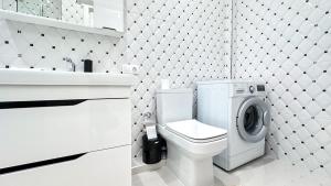 a bathroom with a toilet and a sink and a washing machine at Luxury Residence Business New Apartments in Chişinău +46 photos