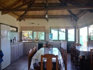 cocina y comedor con mesa y sillas en La Antonia, cabaña al pie de la montaña en Ciudad Lujan de Cuyo