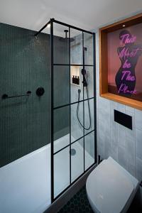a bathroom with a shower with a toilet and a sign at NYX Hotel Dublin in Dublin