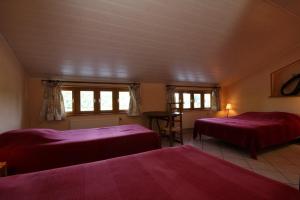 Pokój z 2 łóżkami, stołem i oknami w obiekcie Le champ Vert 